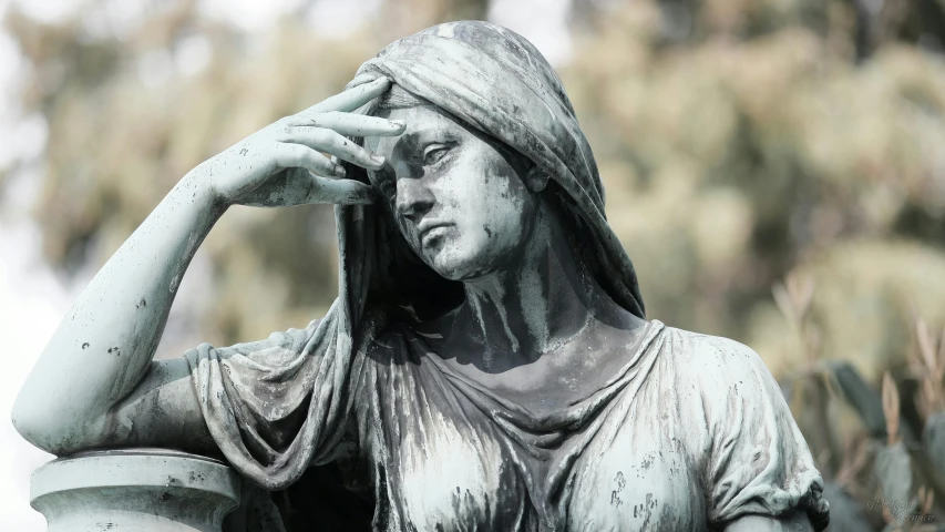 a statue of a woman with her hands up to her head