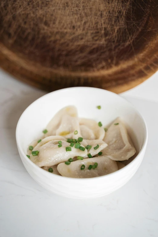 a bowl with dumplings is sitting on the table