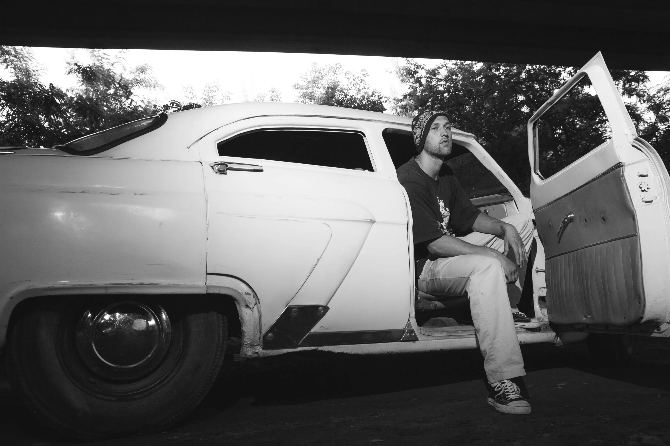 a person leaning out the door of an old car