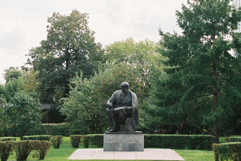 a statue of a man sitting on top of a bench