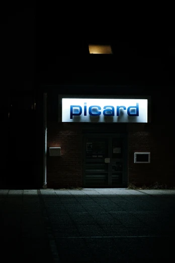 the entrance of a building lit up in the dark