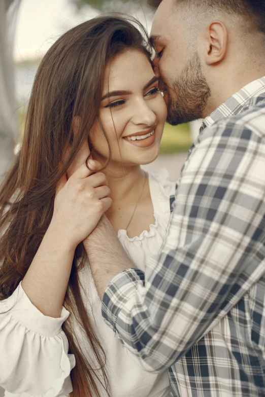 a man standing next to a women holding his face to her chest