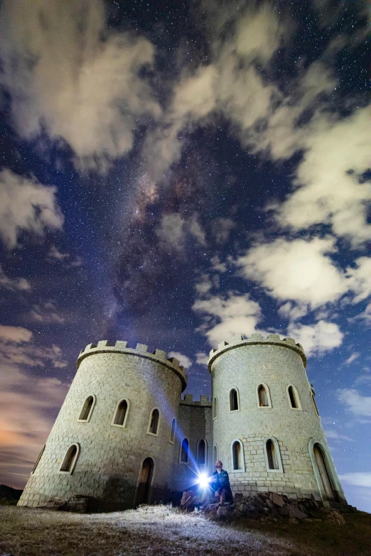 two white towers with a sky full of stars above them