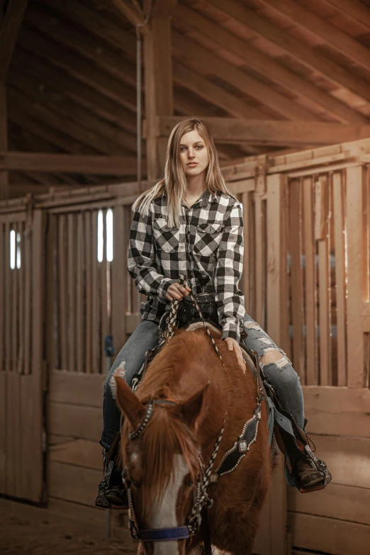 a woman in black and white shirt riding on a horse