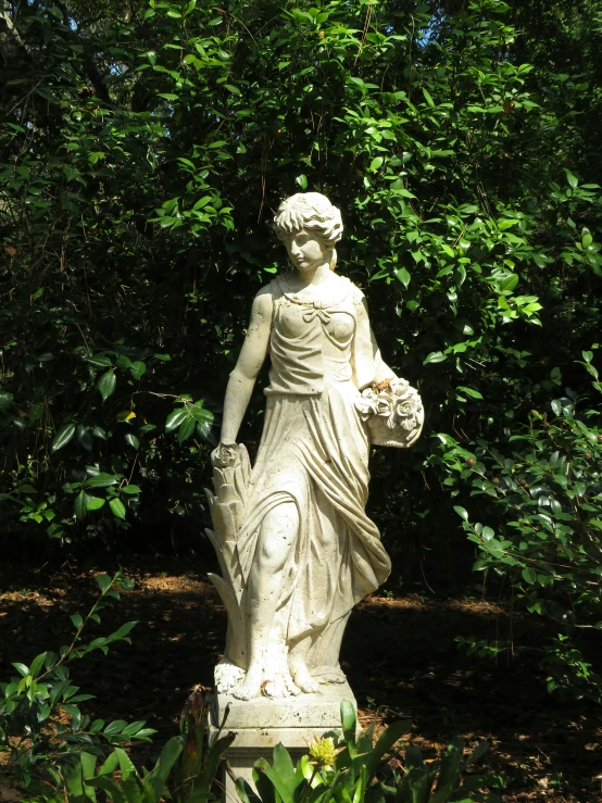 a white statue with a bouquet in its hand