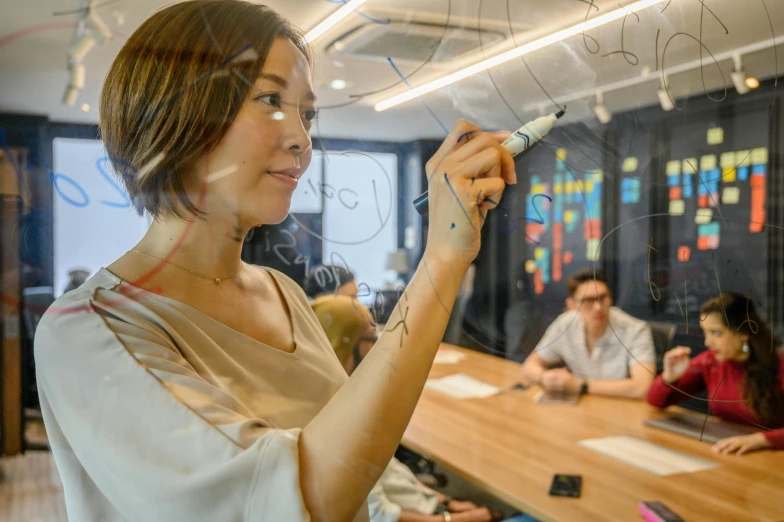 a woman is taking notes from a chalkboard in a classroom