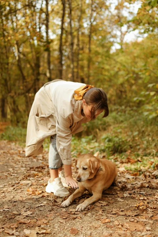 there is a woman bending over with a dog