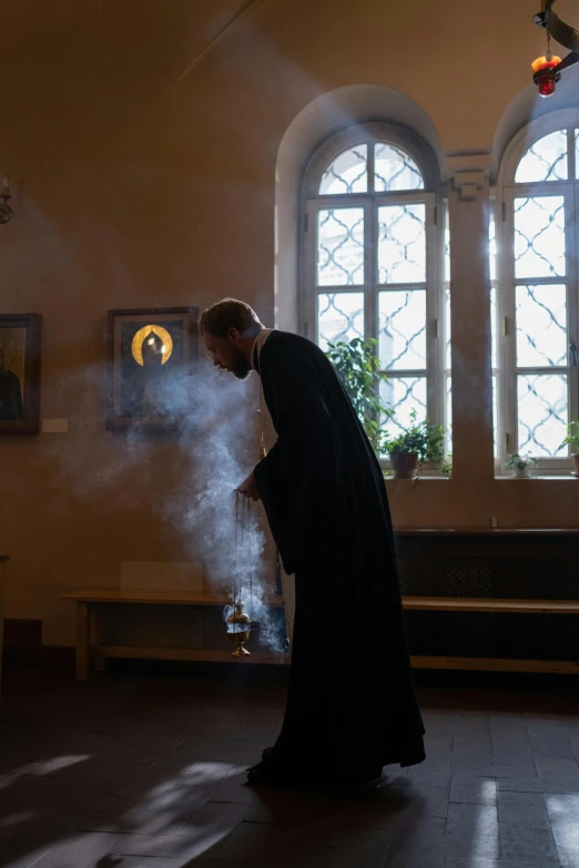 a woman with a nun costume blowing smoke in a church