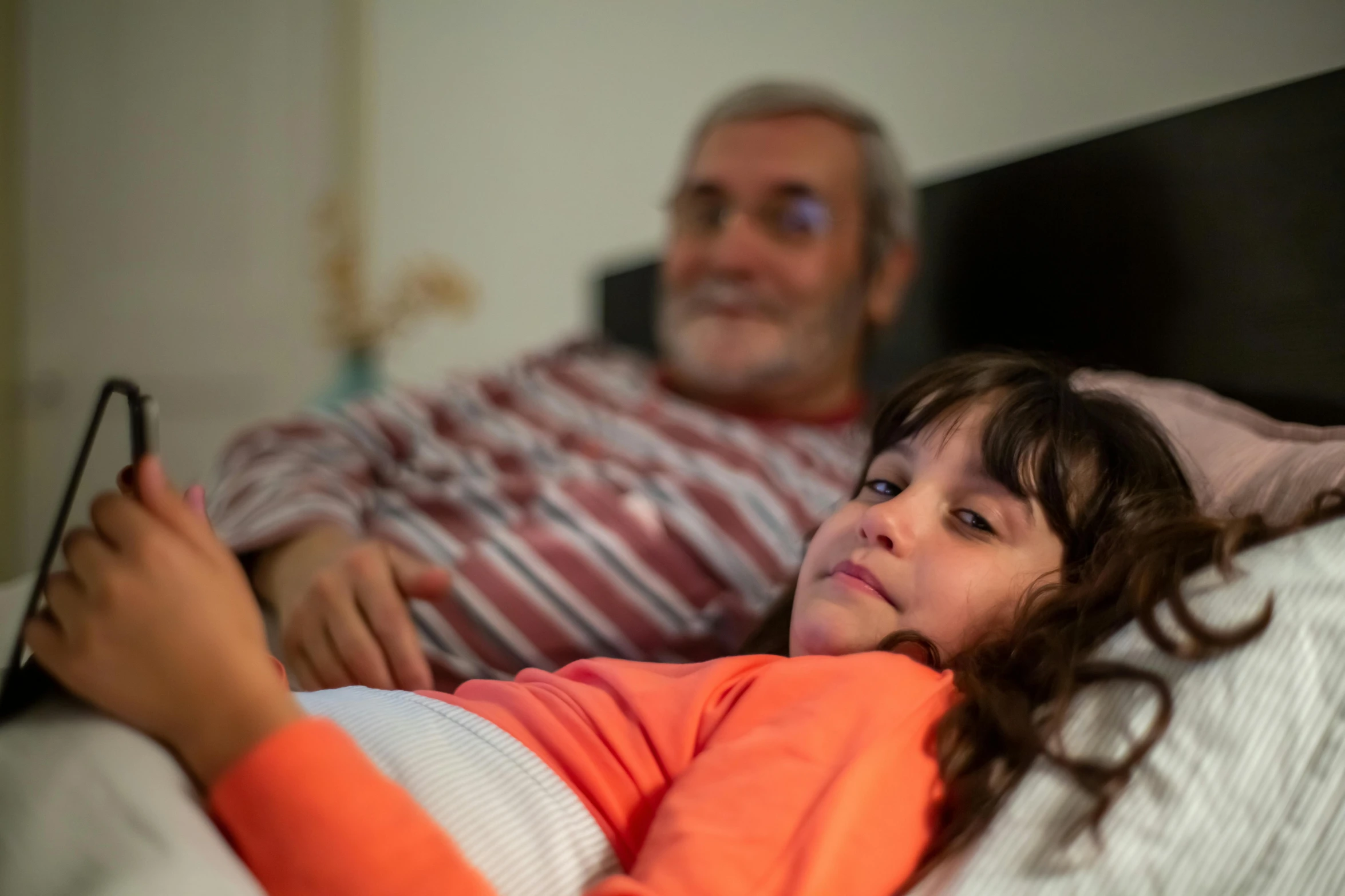 an elderly man watching tv with his daughter