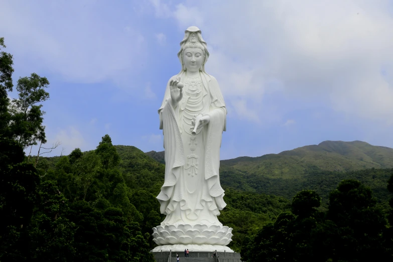 the statue of buddha is standing next to a mountain