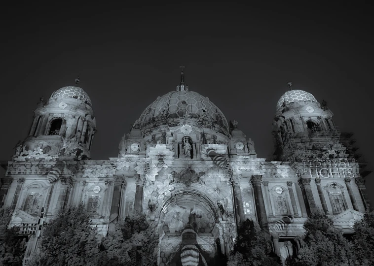 a very tall church with large towers with statues in front