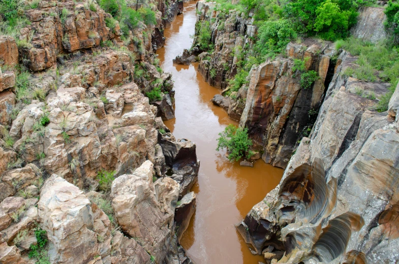 an aerial view of brown water inside of a rocky canyon