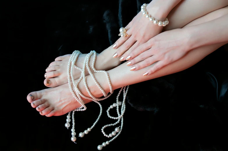 two woman with beaded legs and one wearing pearls