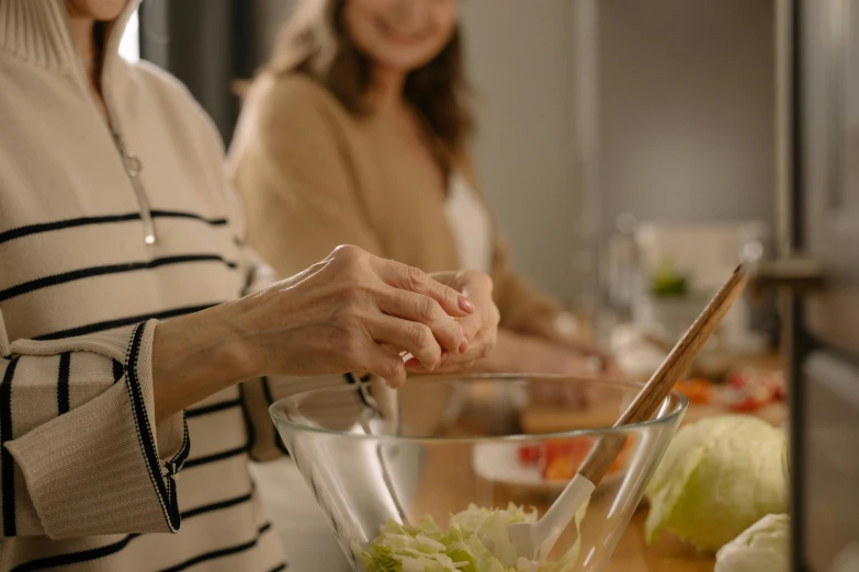 woman standing next to a table  vegetables in a bowl