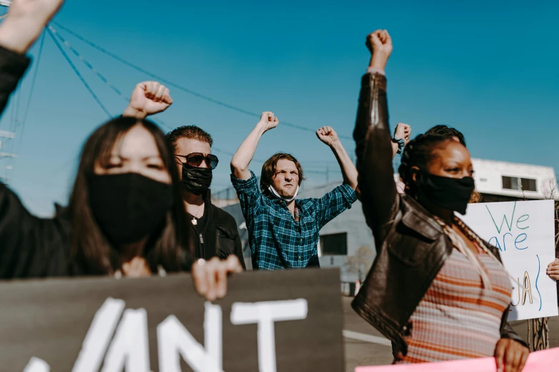 a protest with several protesters and a sign that says anti