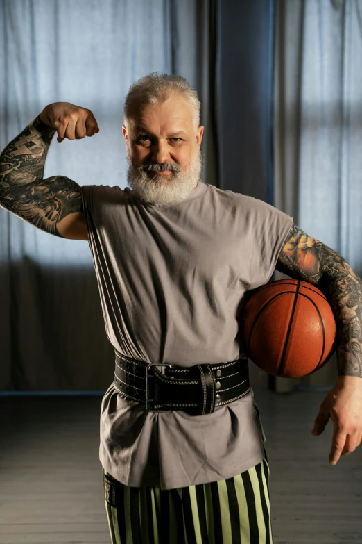 a man is showing off his muscles and holding a basketball
