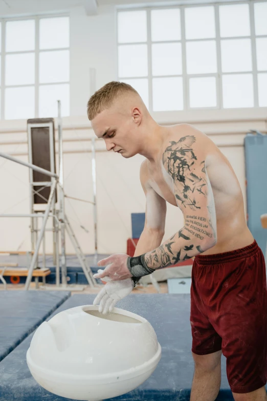 a man with a tattooed arm is washing his hands