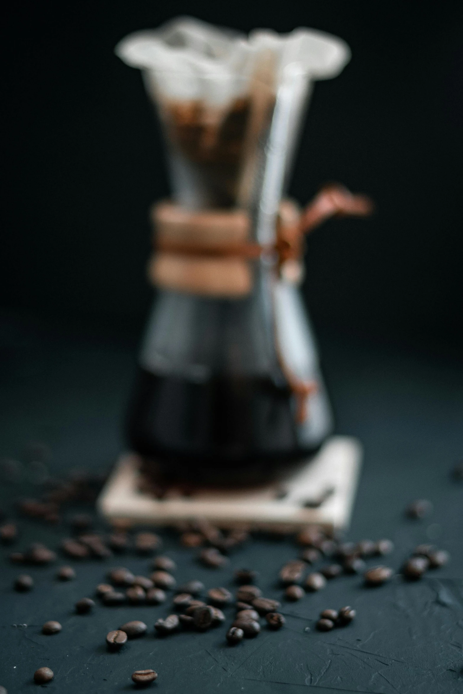 a cup that is sitting on a table with coffee beans