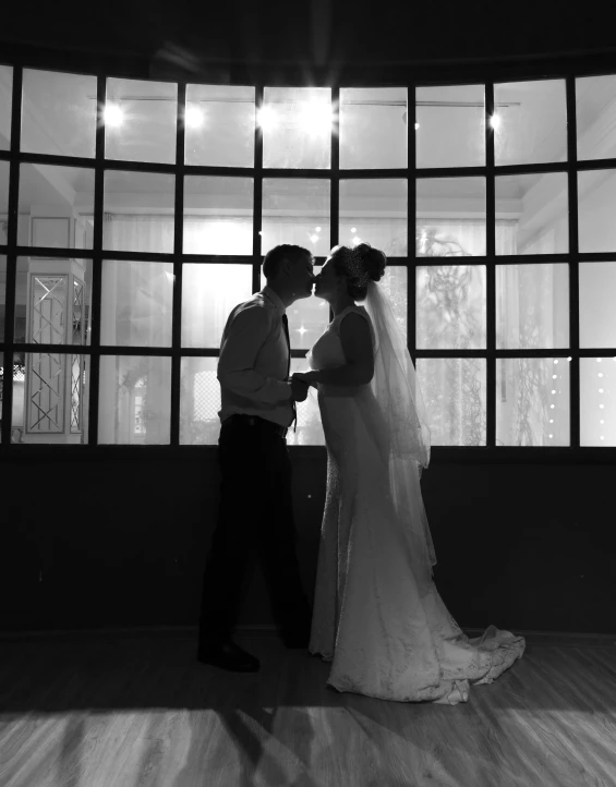 a newly married couple at their wedding in a black and white po