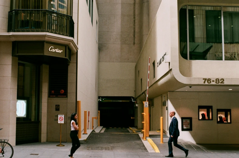 people walking on a sidewalk in front of tall buildings