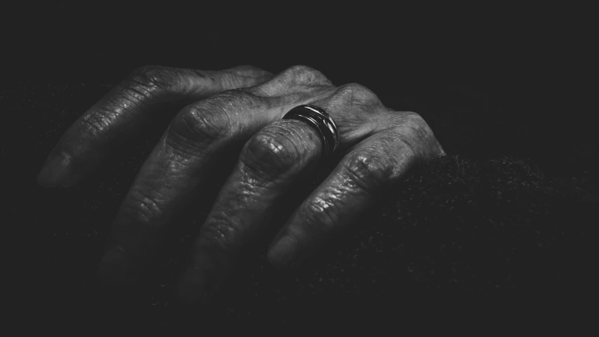 a black and white po of a persons hand with a black ring