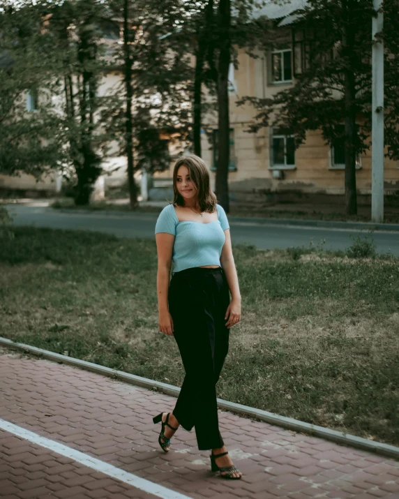 a woman in high heels is walking down the sidewalk