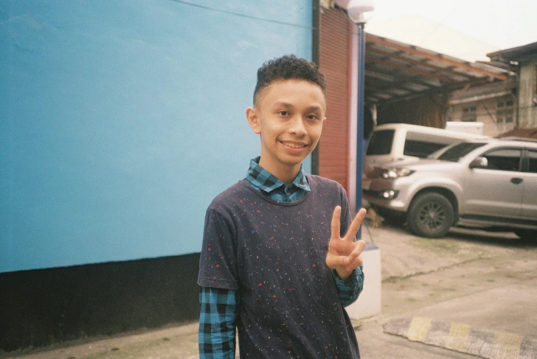 a  posing with his thumb up in a street