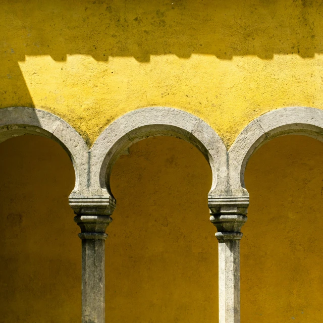 the stone pillars and arches show off what appears to be yellow