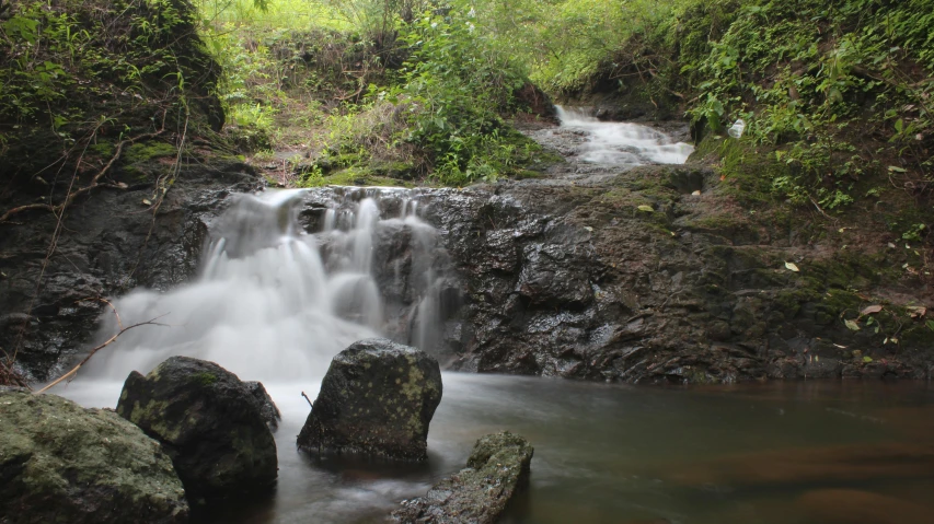 the small waterfall is cascading into the water