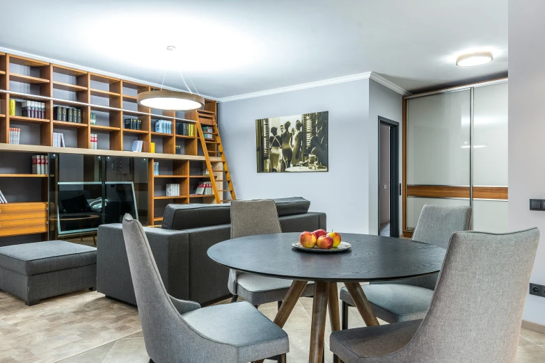 a dining room with bookshelves and a table with chairs