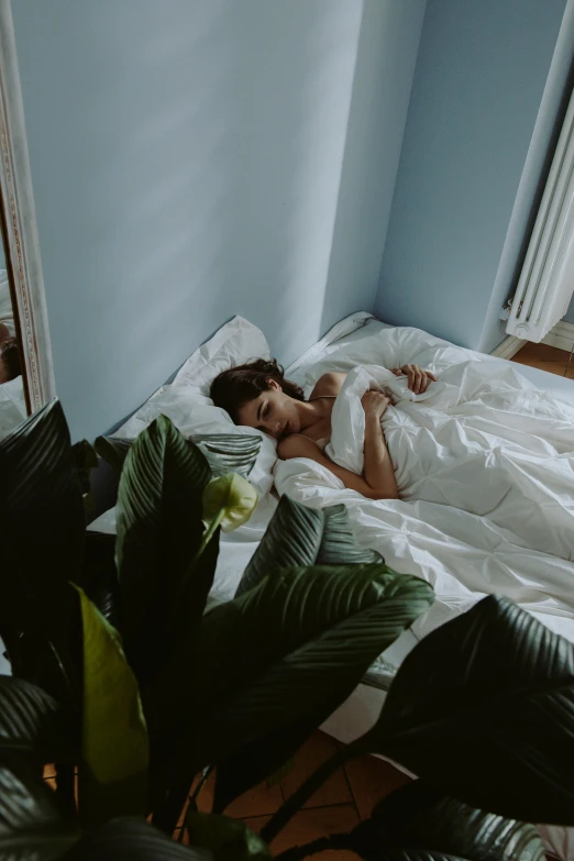 a woman is laying in a bed with monster leaves