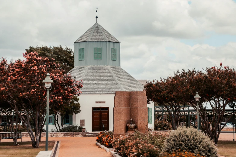 there is a church with a tower and flowers outside