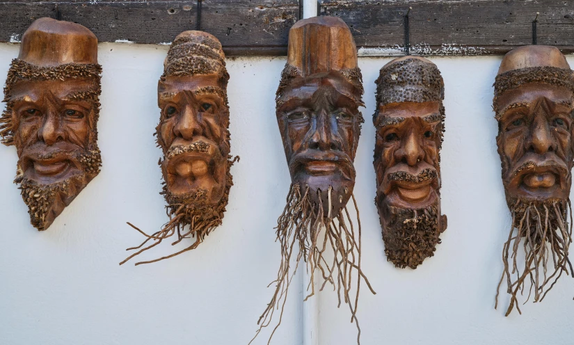 six carvings depicting three men with faces