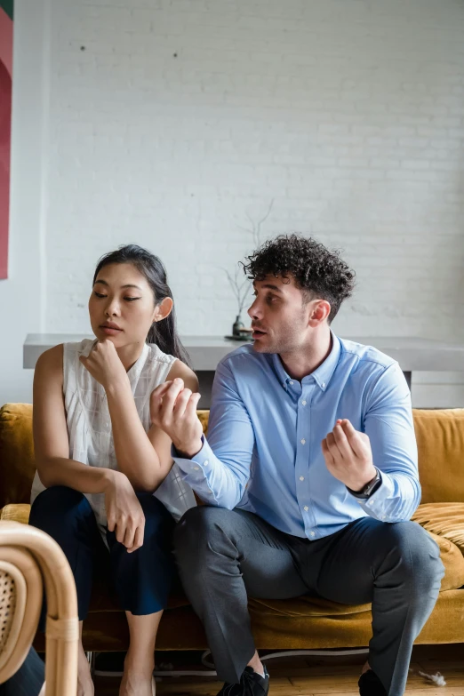 a man and woman sitting on top of a sofa