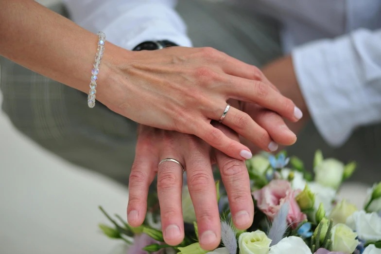 two hands holding each other over a bouquet