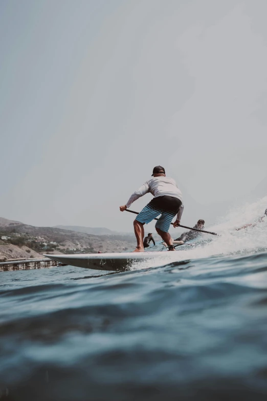 a person standing on the water in front of a wave