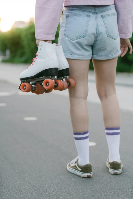a person holding two roller skates and some socks