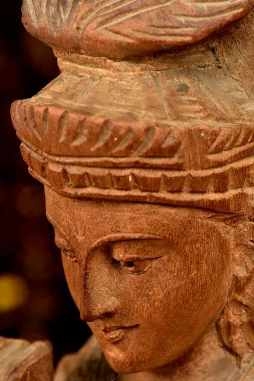 a red wooden statue is shown with a bird on its head