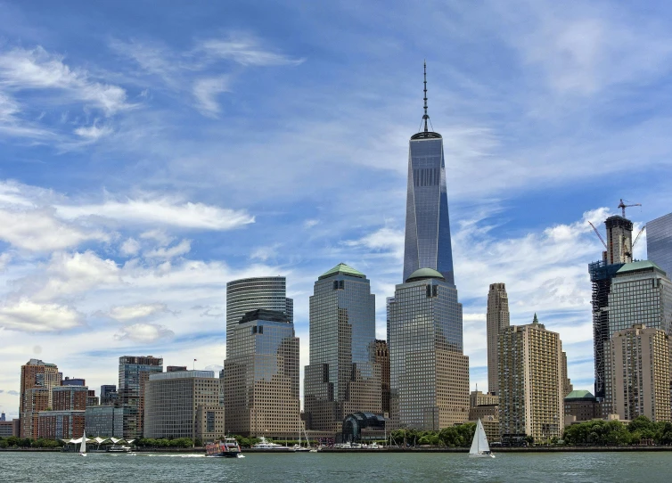 a group of boats floating in a harbor near tall buildings