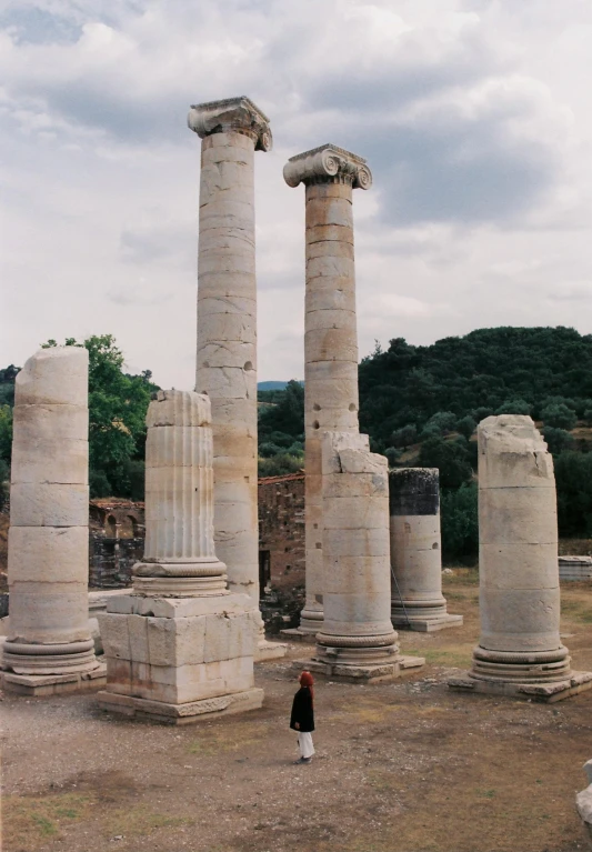 a girl standing in between a group of large pillars