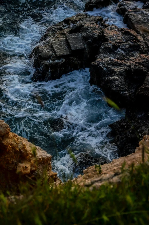 the ocean waves are breaking through the rocks