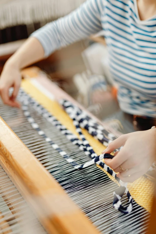 a woman is using a sewing machine for weaving material