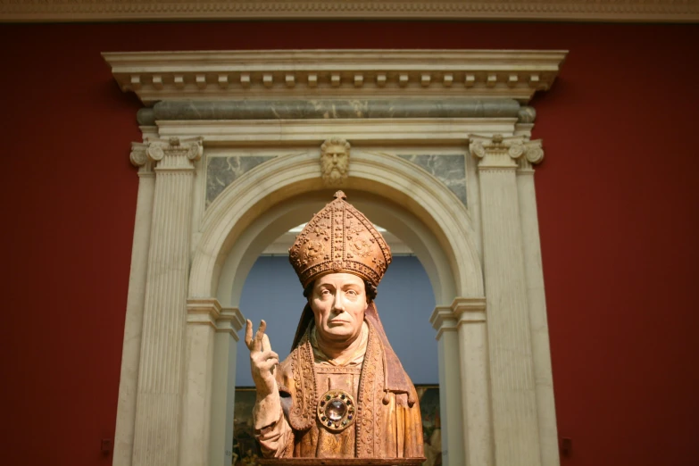 a wooden statue of a saint with a crown