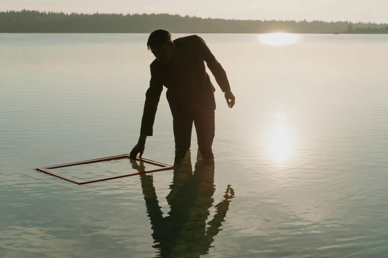 a person standing in the middle of a lake at sunrise