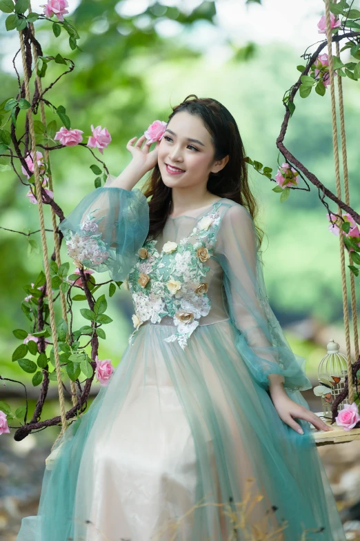 a woman in a dress and a swing with pink roses