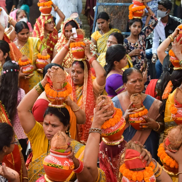several women with orange scarves and yellow necklaces perform a trick