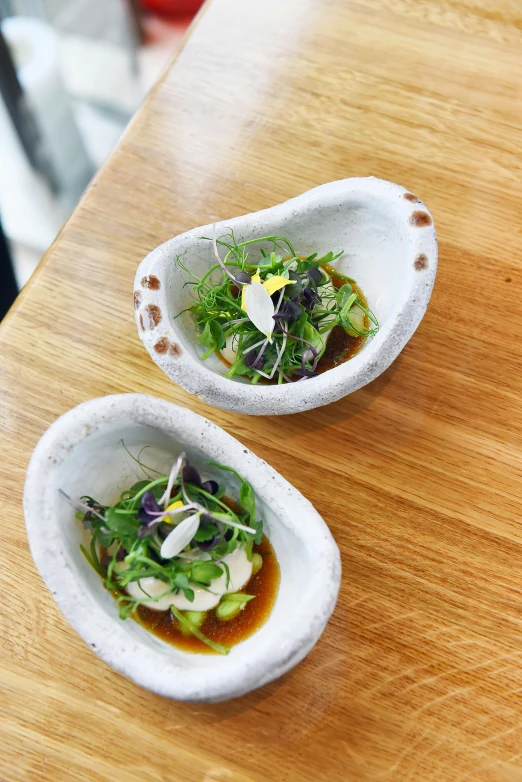 two dishes sitting on top of a wooden table