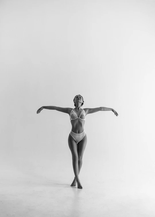 a female ballet dancer in a white dress poses for the camera