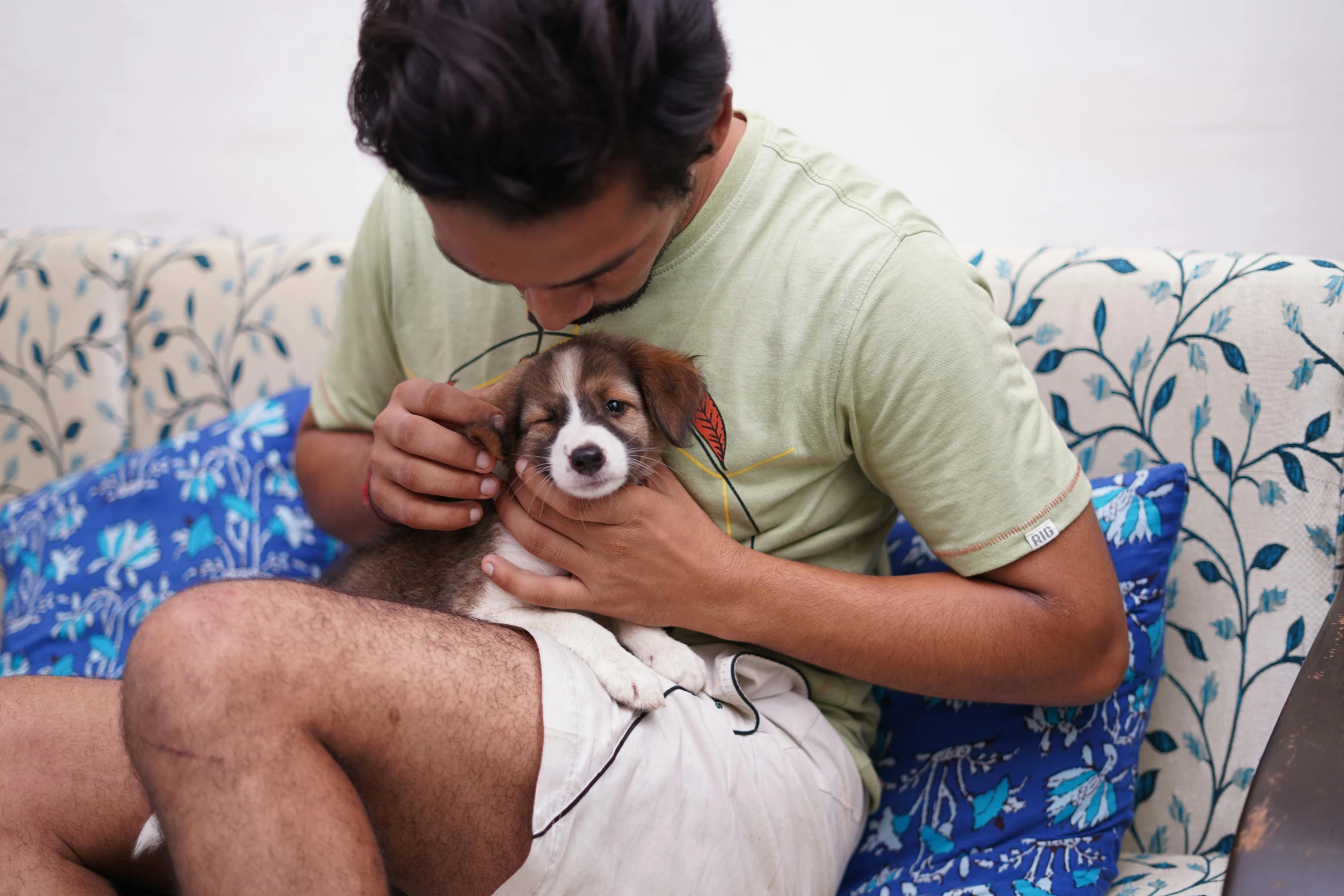 a man sitting on a couch with his dog