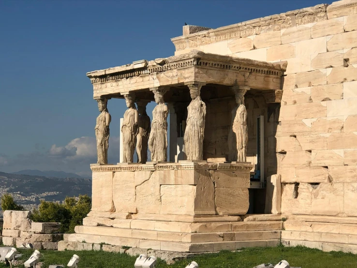 an outdoor view of a building with two columns and the ruins